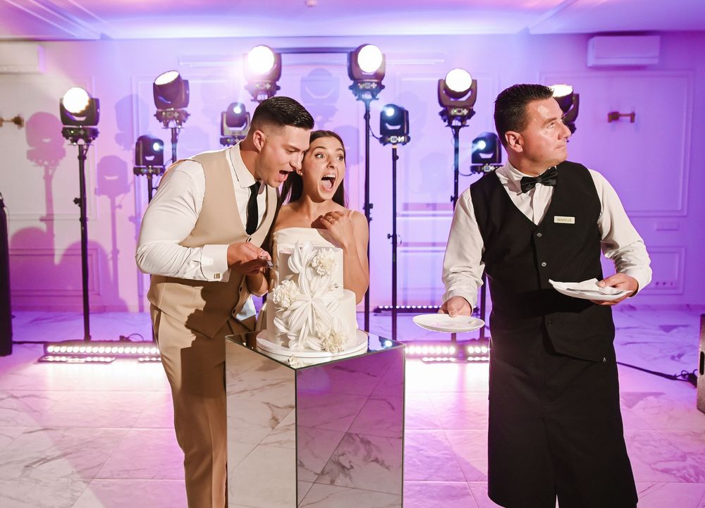 Wedding guests dance together at a reception with purple uplighting and a romantic atmosphere.