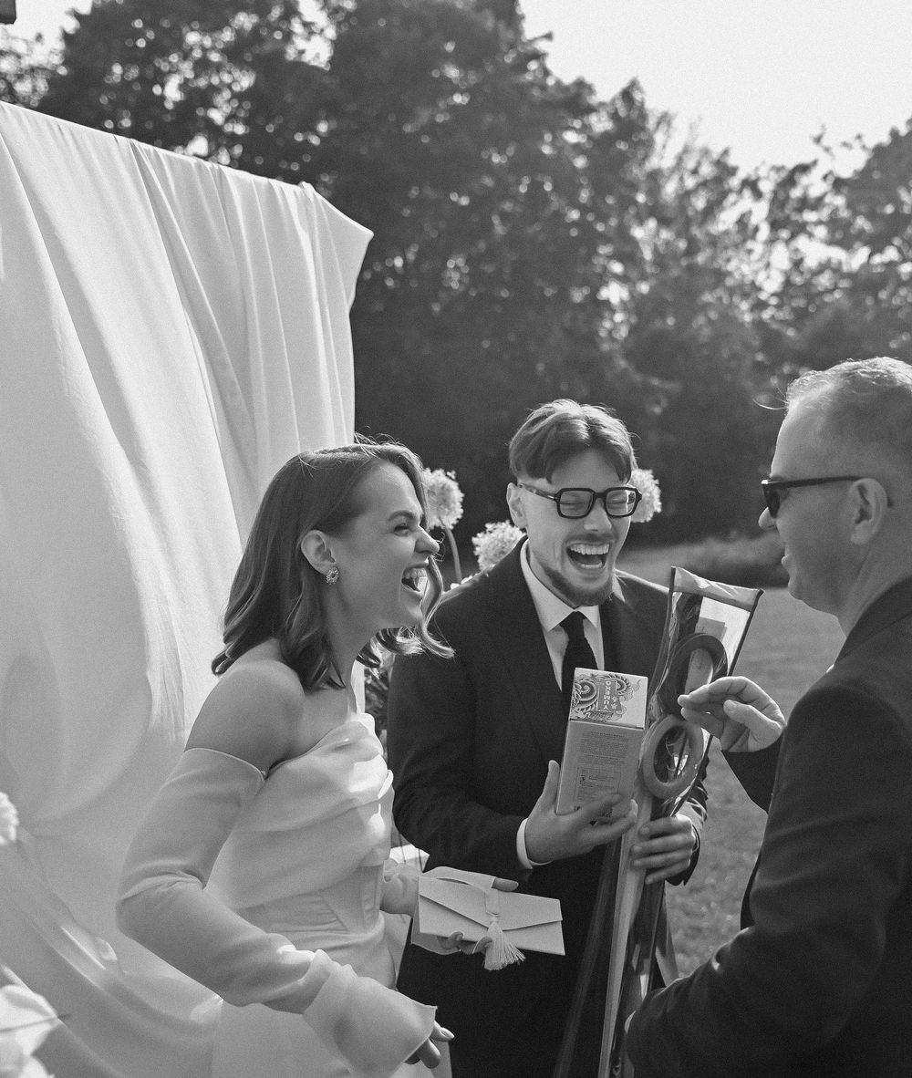 A sequence of five black and white photos showing a joyful moment at an outdoor event with white curtains in the background.