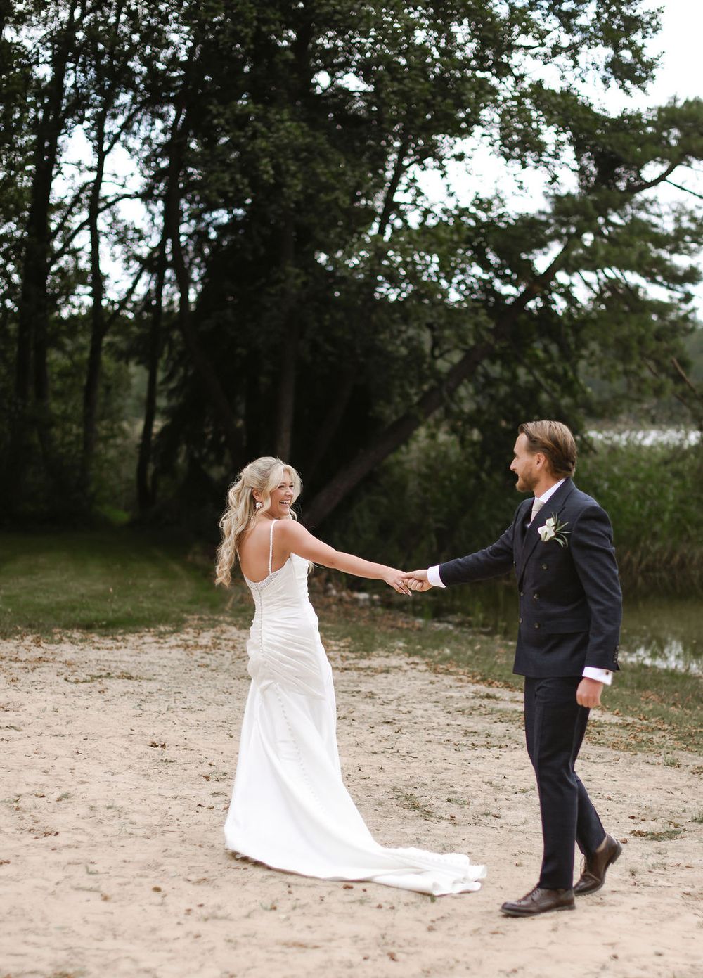 A romantic dancing sequence photographed on a sandy beach shows graceful movement between a couple in wedding attire.