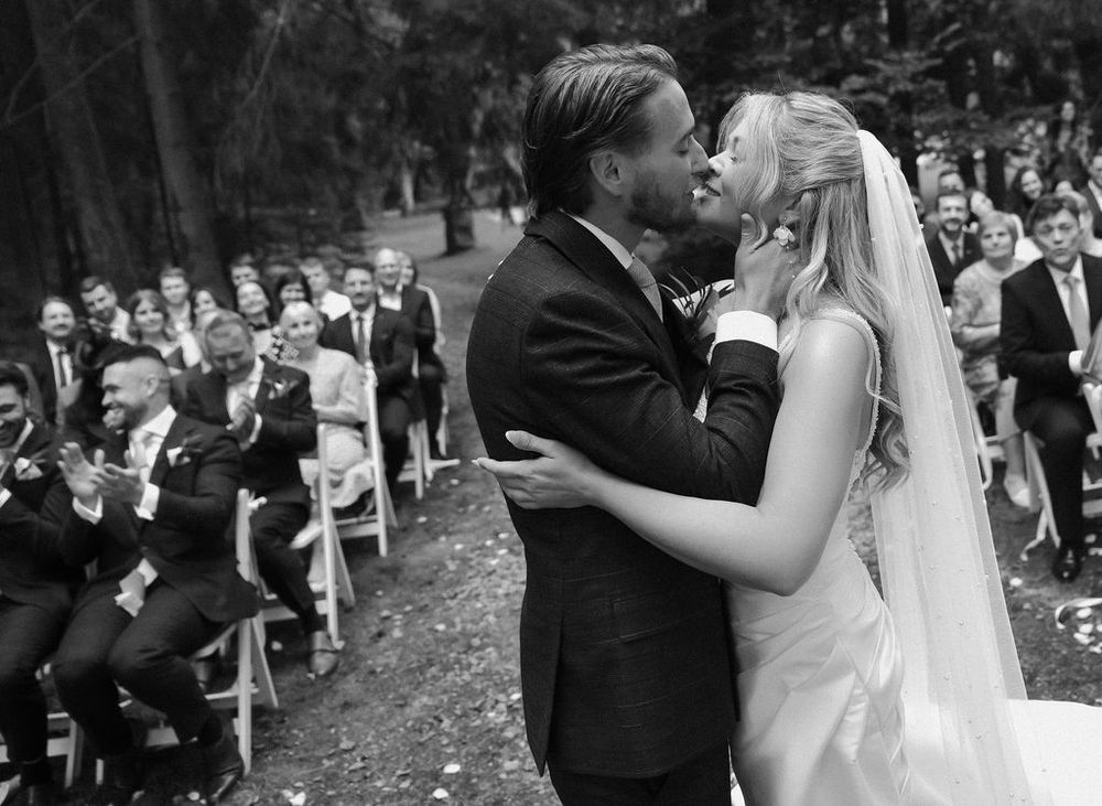 A sequence of black and white wedding photos shows romantic moments between the couple during their outdoor ceremony.