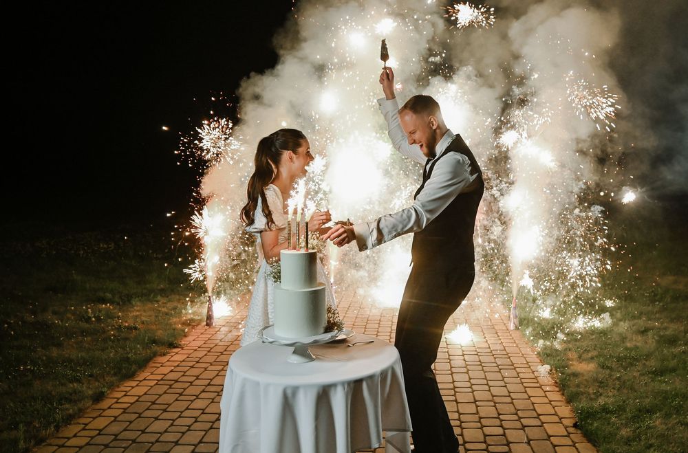 Romantic wedding sparkler exit at night with couple walking through glowing sparklers held by guests.