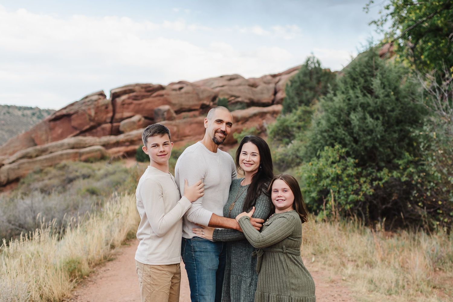 Colorado family posing in Red Rocks Park during their family photo session. Family Photographer based in Denver Colorado. Red Rocks photos