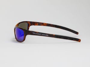 Side profile of sport sunglasses with brown frames and blue mirrored lenses. Luxury product photography.