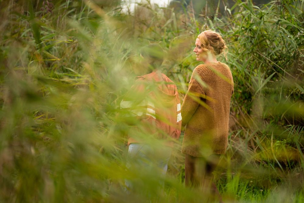 Irena van den Berg, Bergkompas, psychologe buiten haar praktijk begeleiding gevend tussen hoog riet wandelend. Mooi onscherpe omgeving.