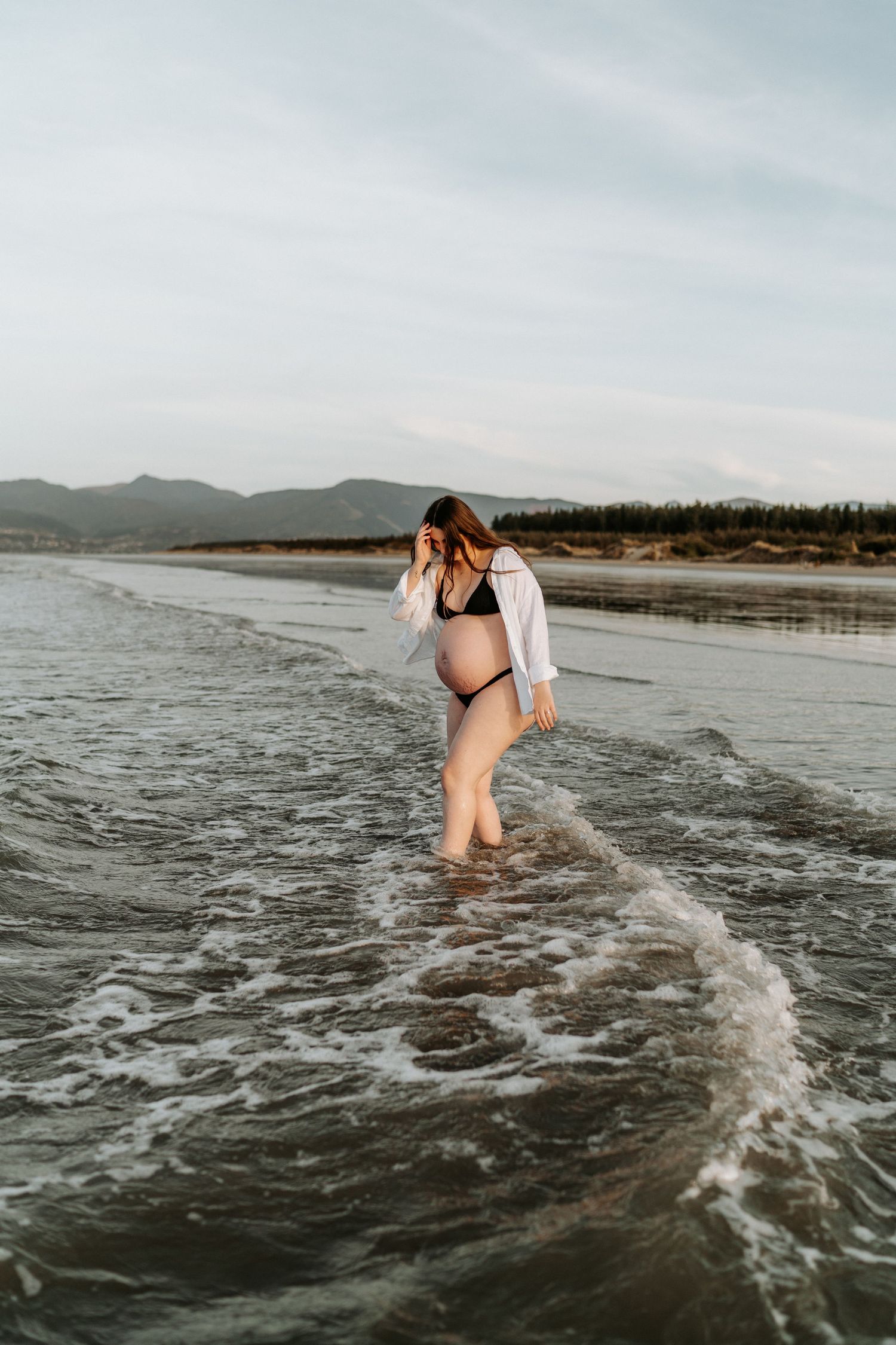 A natural maternity photo taken at golden hour on a Mornington peninsula beach