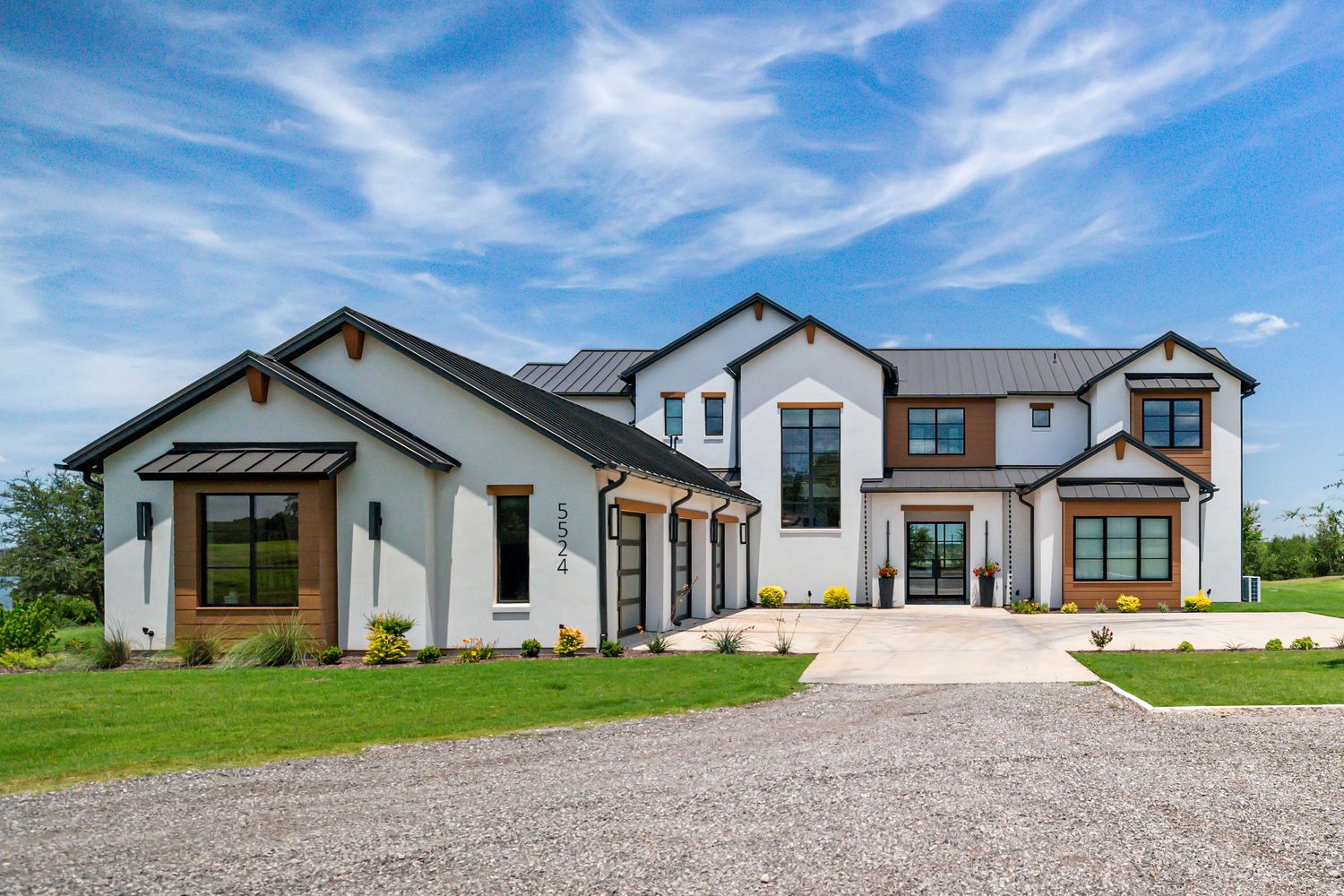 drone footage of large two story home on top of hill surround by trees