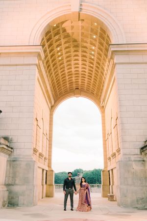 A series of romantic poses under a grand white stone archway.