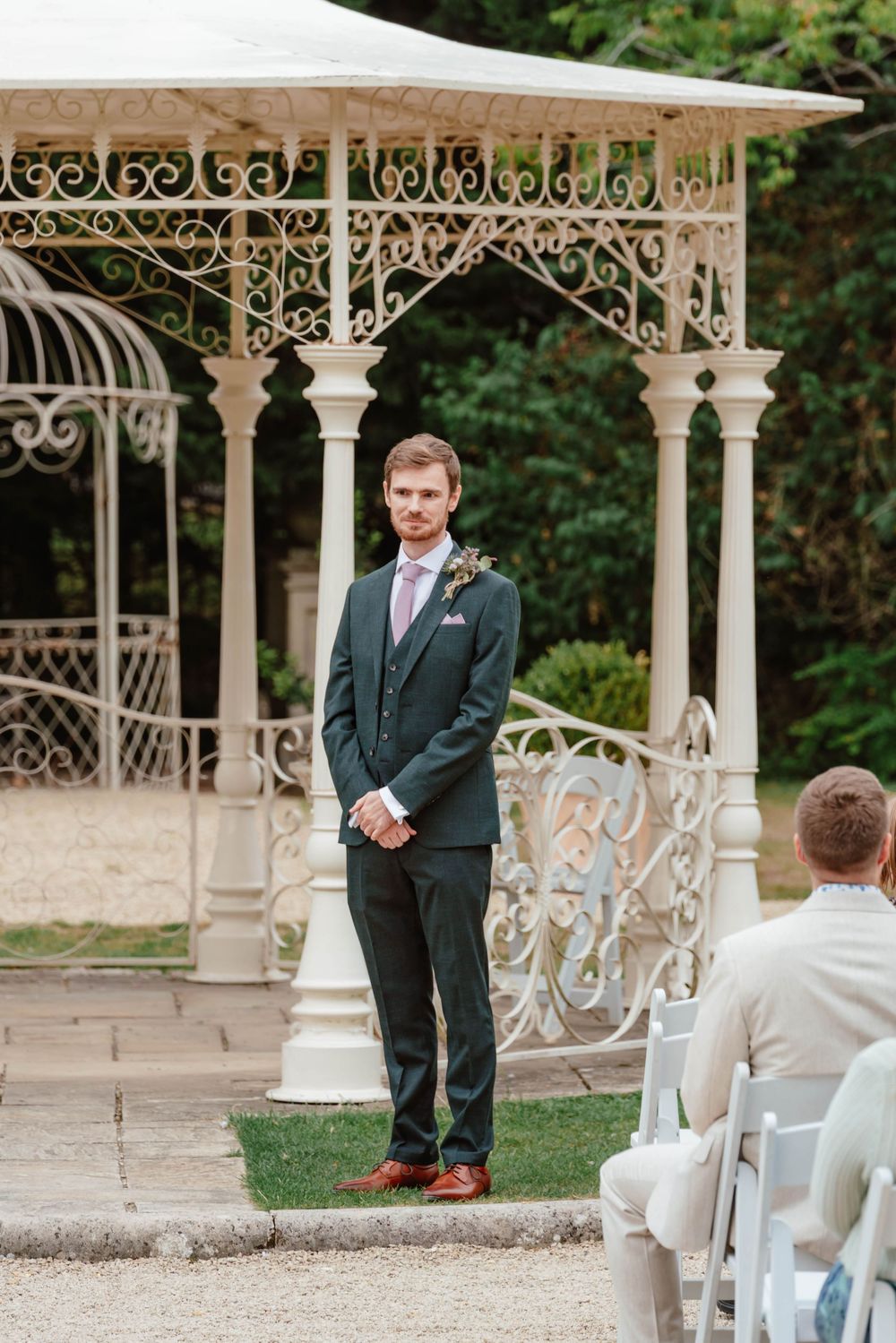 Wedding at Manor by the Lake Cheltenham Gloucestershire groom waiting by pergola outside