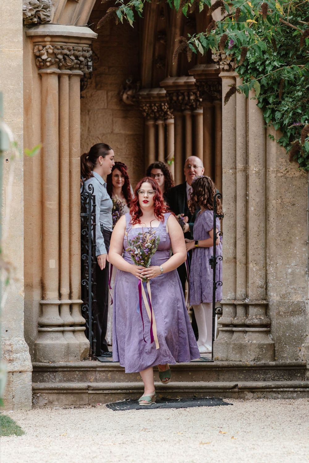 Wedding at Manor by the Lake Cheltenham Gloucestershire bridesmaid walking aisle outside ceremony