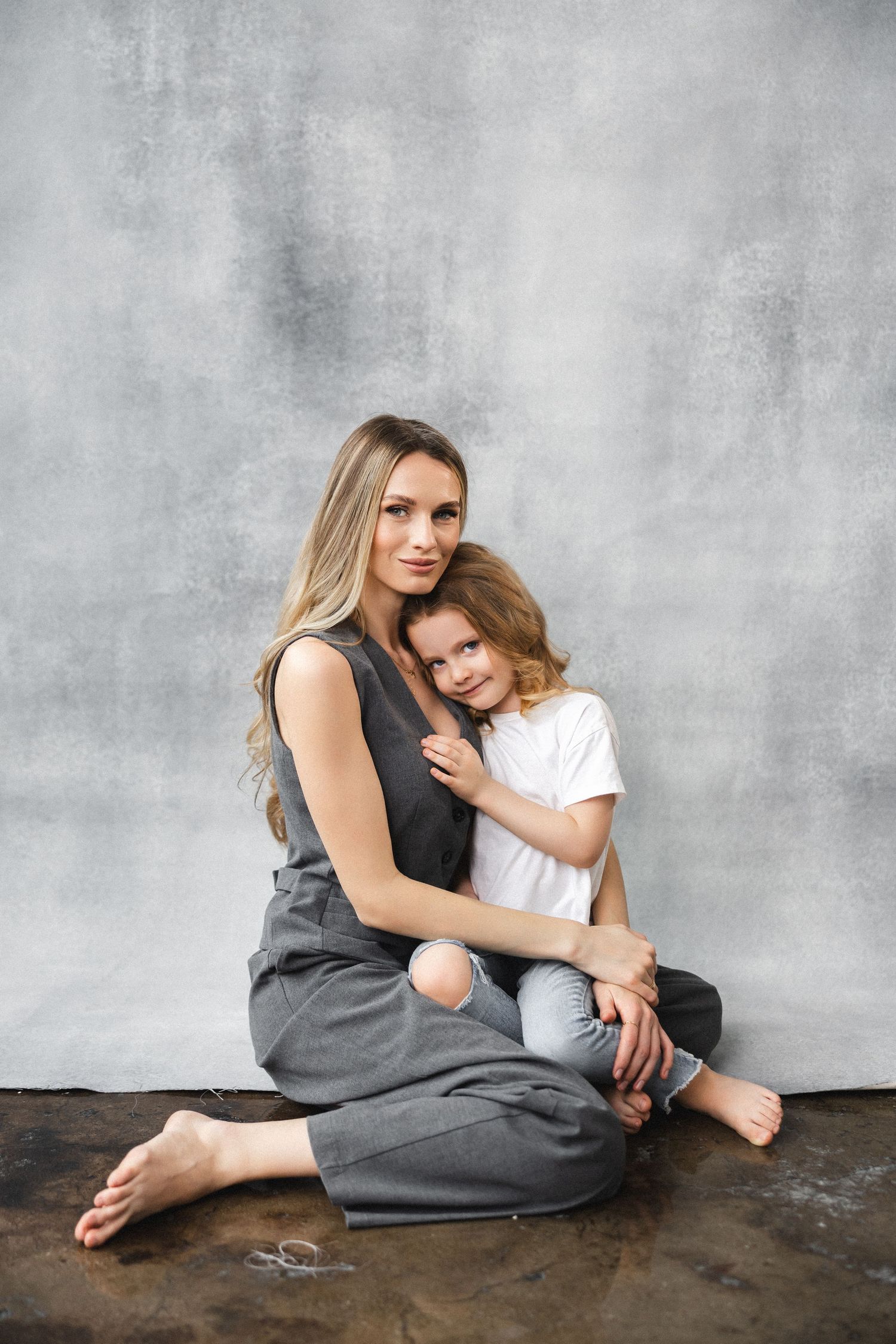 Intimate portraits in grey tones showing tender moments against a textured wall.