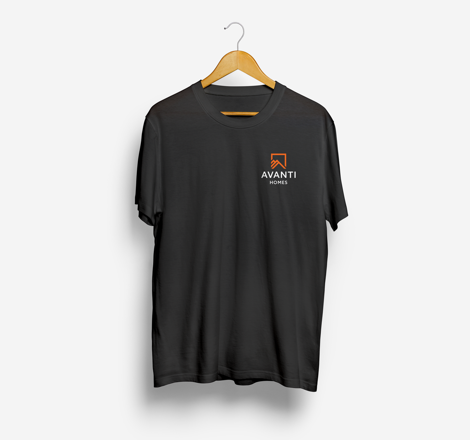 Black t-shirt with Avanti Custom Homes logo hanging on wooden hanger against white background.