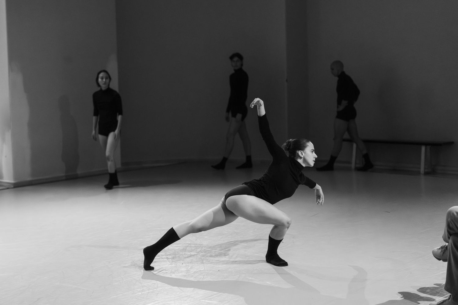 A sequence of dance poses showing a performer executing graceful stretches and movements on a light colored floor.