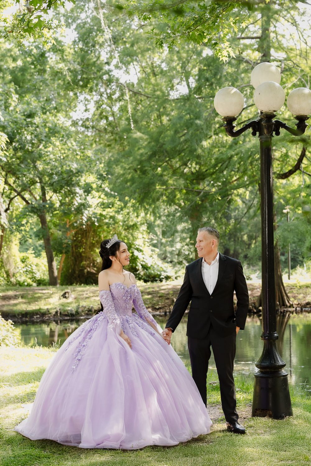 Lavender princess ball gown photographed in a scenic park setting with vintage lampposts.