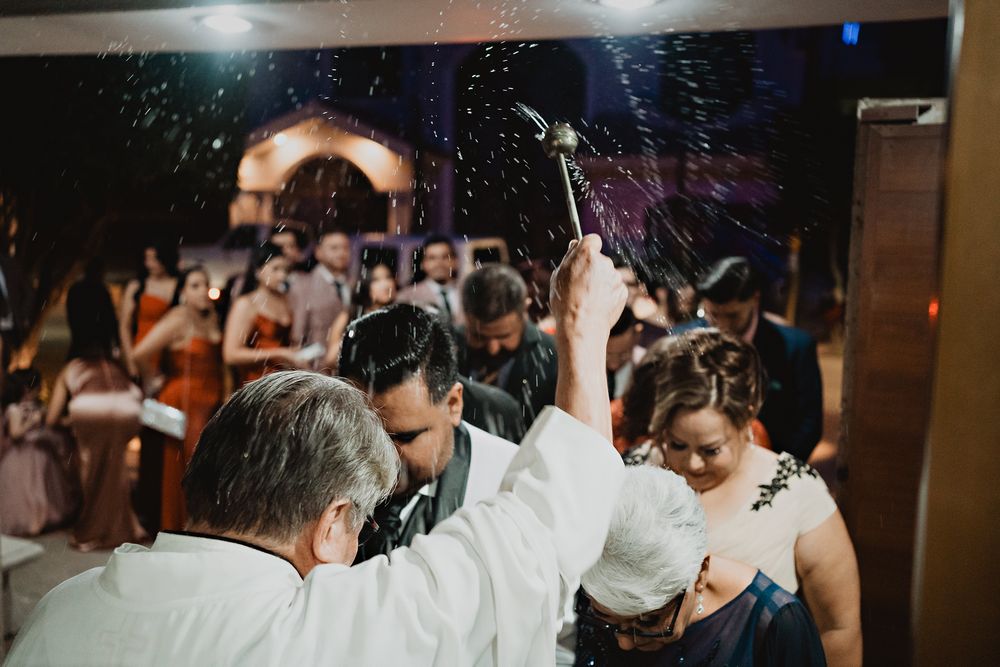 Wedding party celebrates on a dance floor at a dimly lit reception venue during a festive evening celebration.