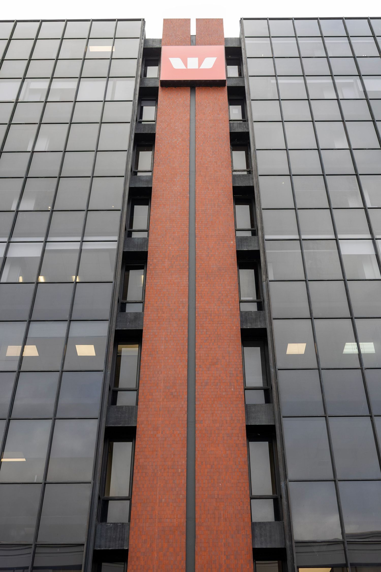 Bold red vertical feature running through the centre of a black-glass office building with the Westpac logo at the top.