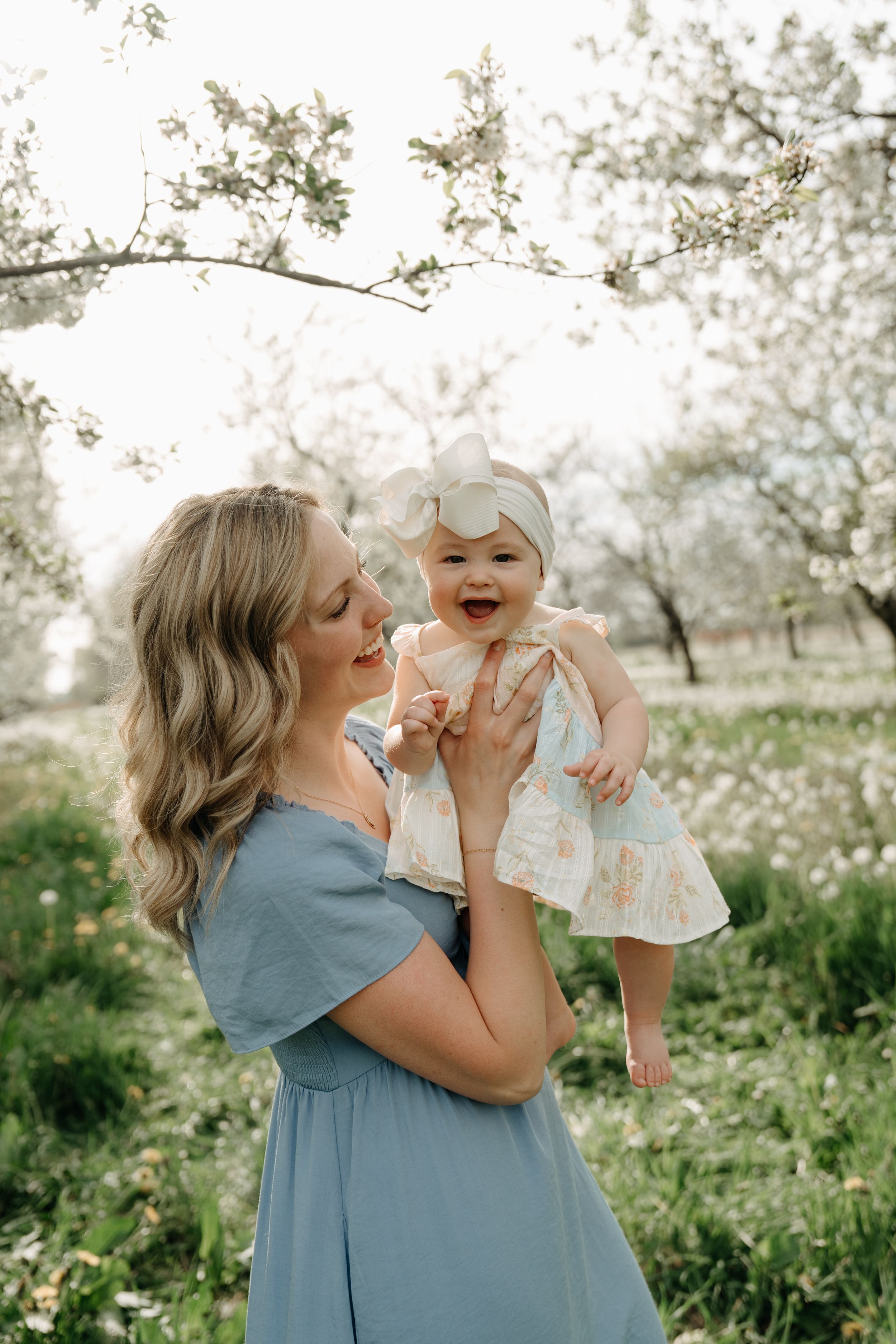 A tender moment shared among blooming cherry trees and wildflowers in an orchard.