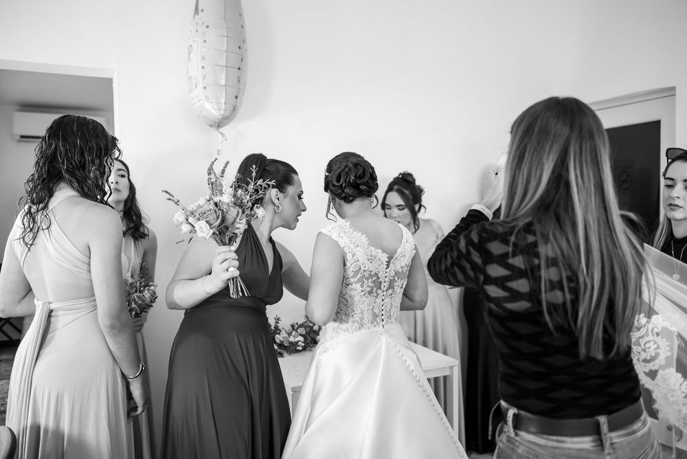 A group of women in formal attire gather together in a bright indoor setting for a celebratory event.
