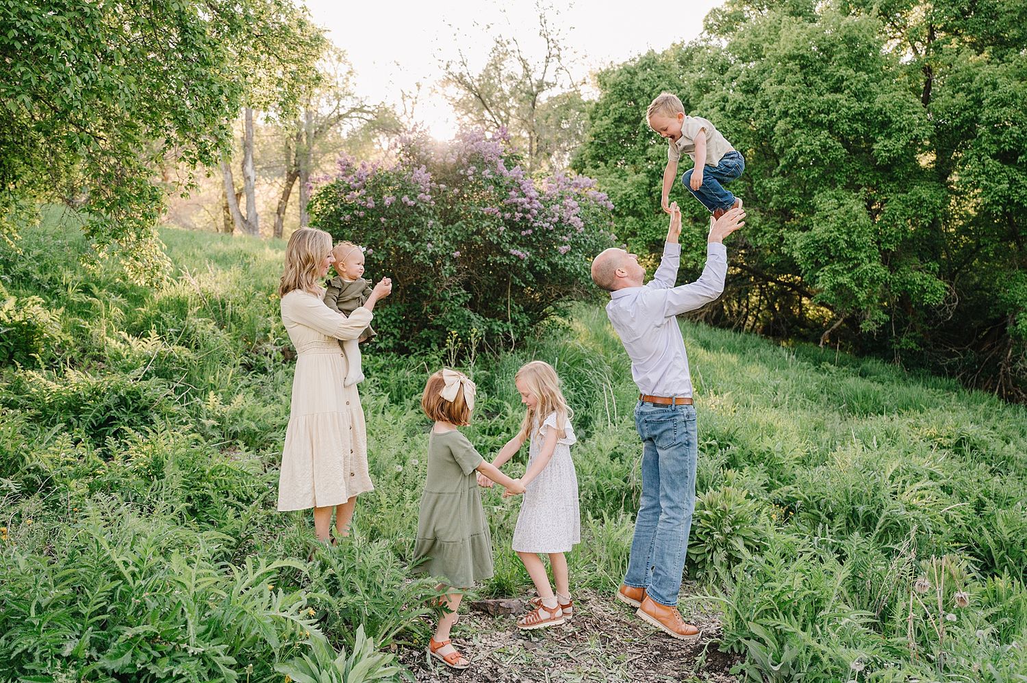 Family enjoying a sunny day together in a lush green garden setting during springtime.