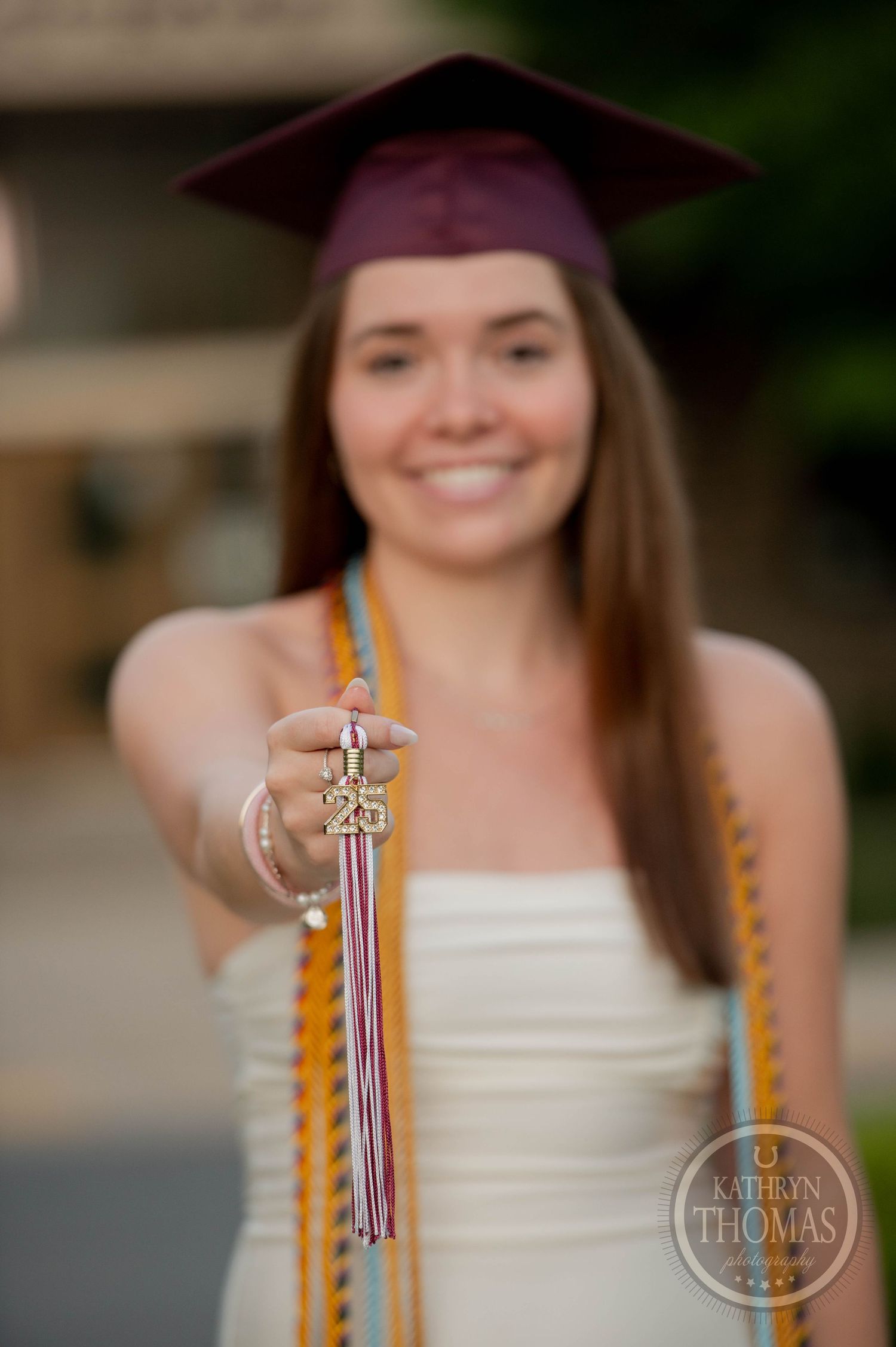 A graduation photoshoot sequence showing someone holding a diploma while wearing a burgundy cap and white dress.
