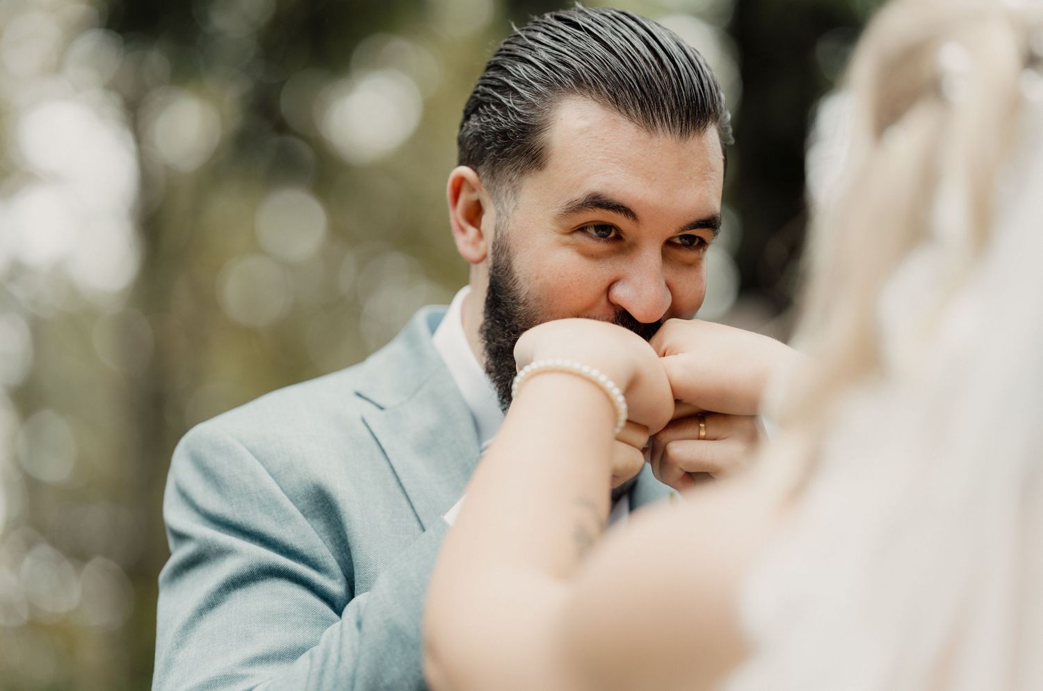 Bräutigam küsst liebevoll die Hand der Braut nach der Hochzeit.