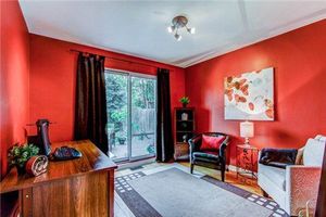 Modern bedroom with vibrant red walls, dark curtains, and sliding glass doors leading to outdoor space.