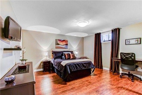 Modern bedroom with hardwood floors, wall-mounted shelving, and contemporary bedding.