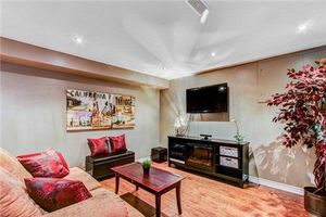 Basement living room with red accents, modern entertainment center, and comfortable seating arrangement.