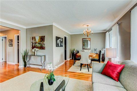 Bright living room with hardwood floors, sofa, and modern accent furniture.