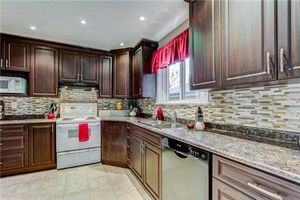 Elegant kitchen with dark wood cabinets and glass tile backsplash.