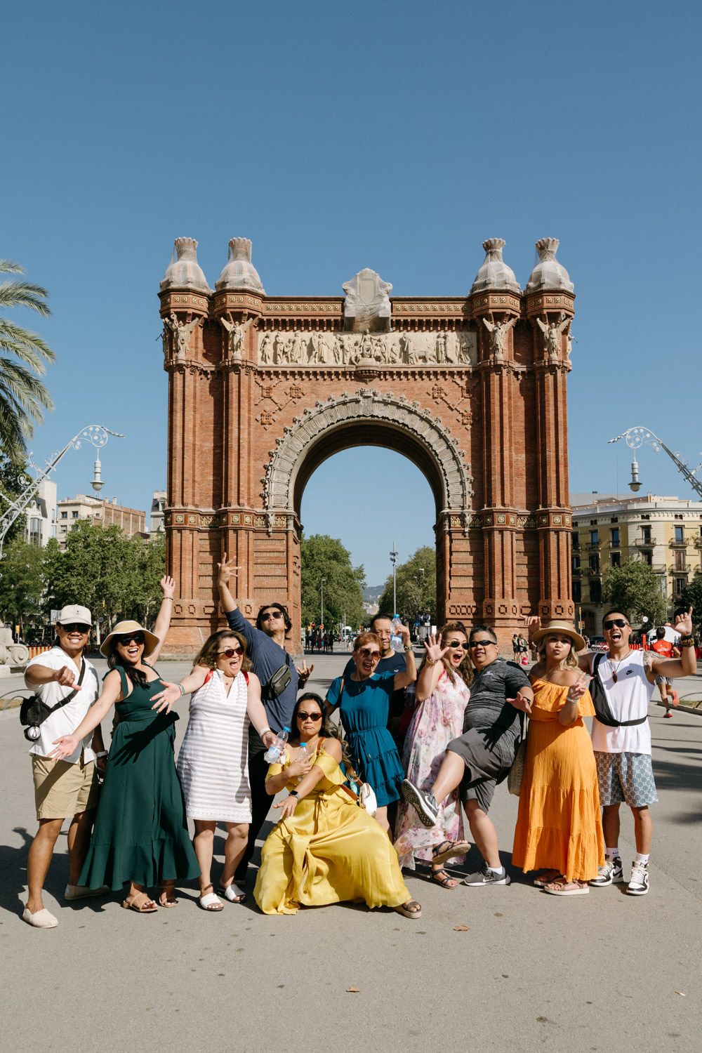 Large group posing for photo in front of Barcelona's iconic Arc de Triomf monument.