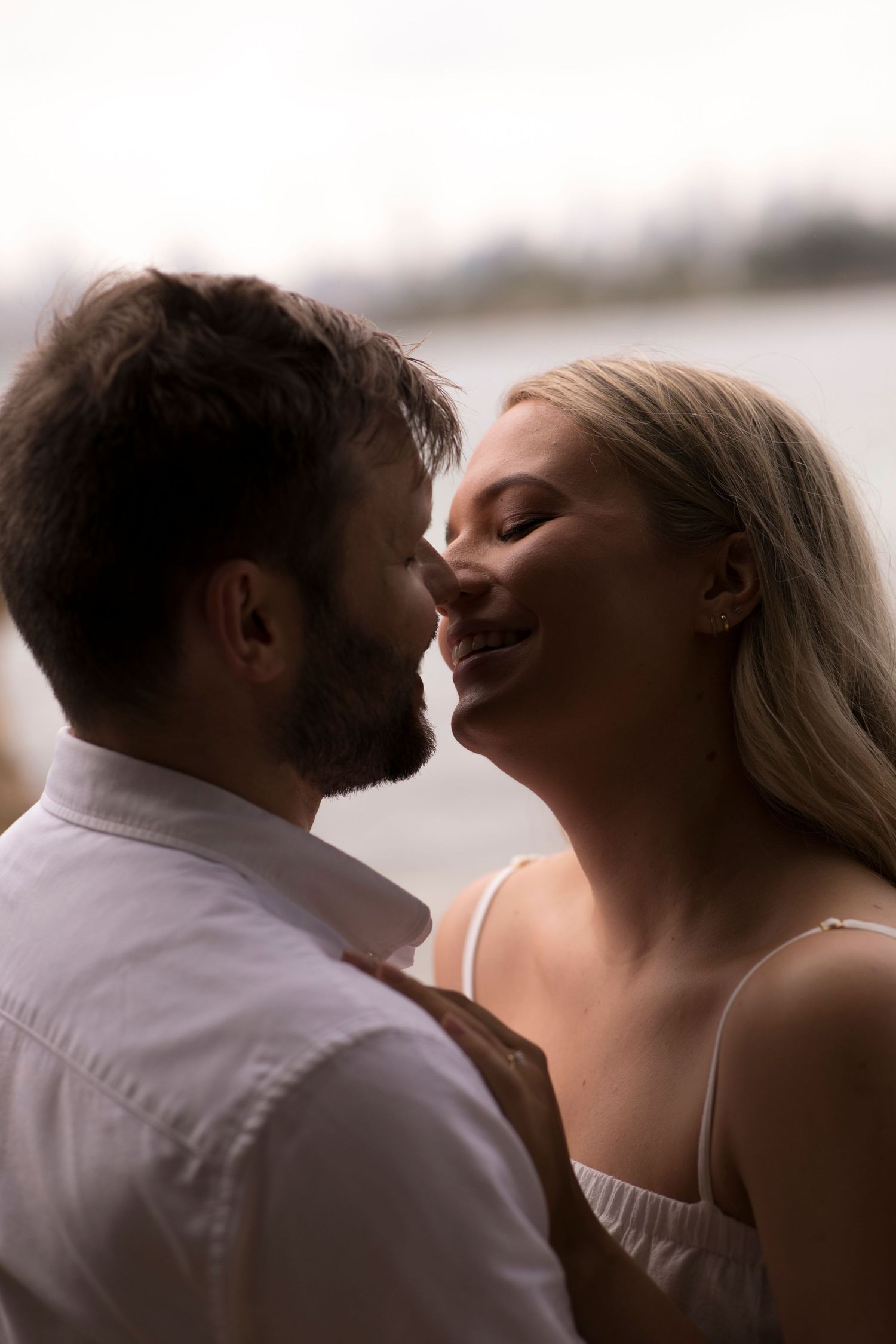 Intimate close-up of couple sharing tender moment against blurred background.