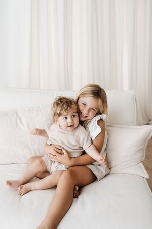 Sweet bonding moments on a white couch captured in sequence with natural lighting.