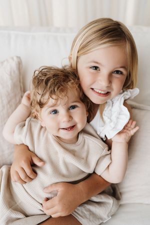 Joyful embraces and smiles shared in a bright white setting.