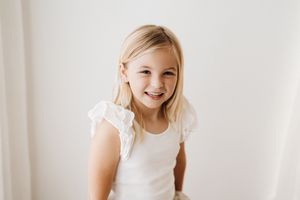 Bright natural portraits against white backdrop showing joyful expressions.