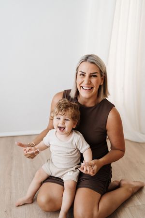 Candid moments of joy and laughter shared on light wooden flooring.