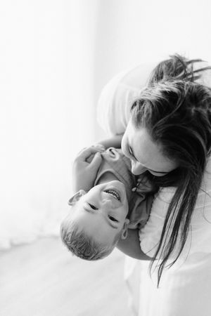 Black and white portrait capturing joyful bonding moment against white background.