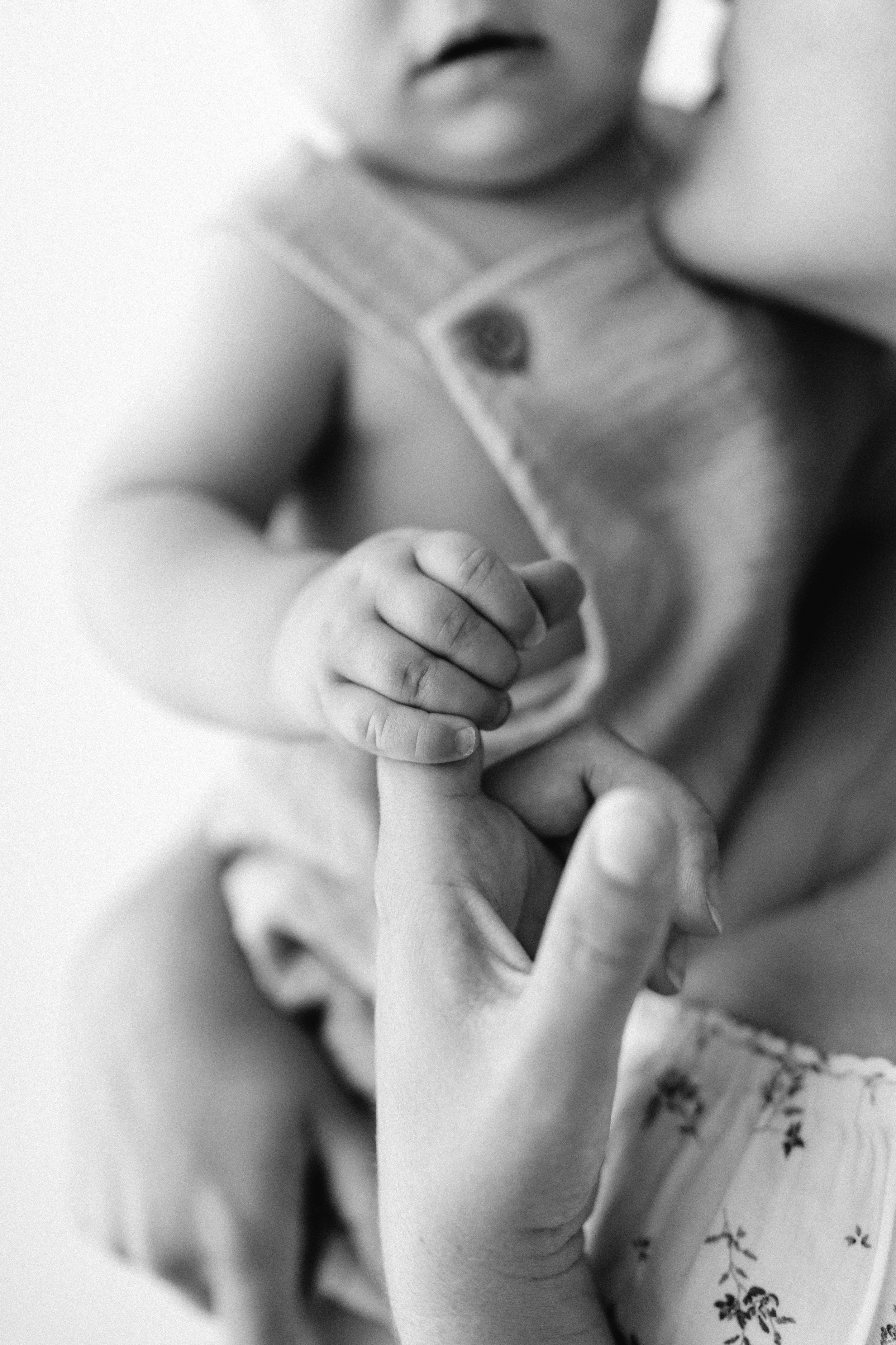 Black and white close-up series of baby's tiny hands and fingers.