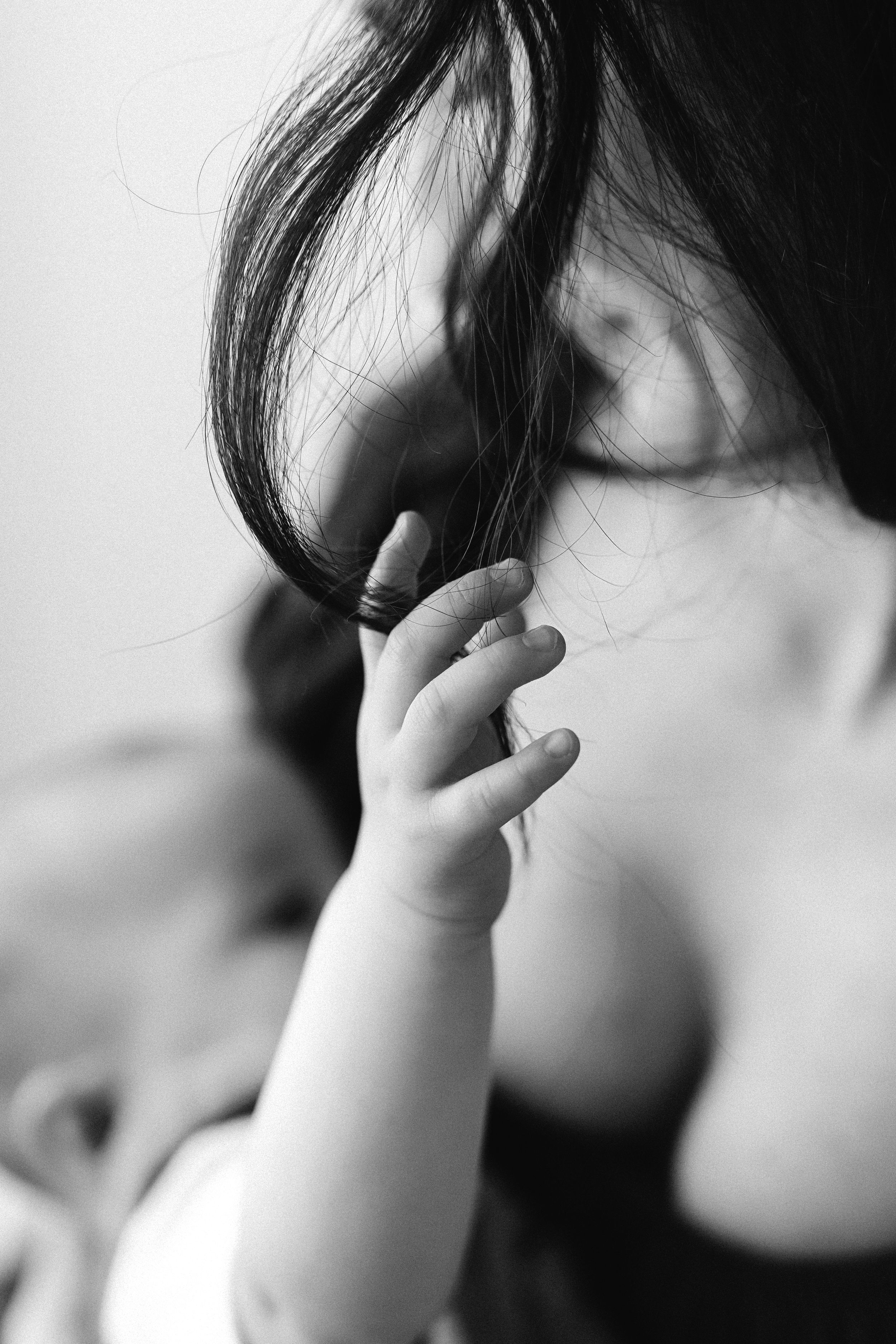 Black and white artistic series showing baby's hand near face.