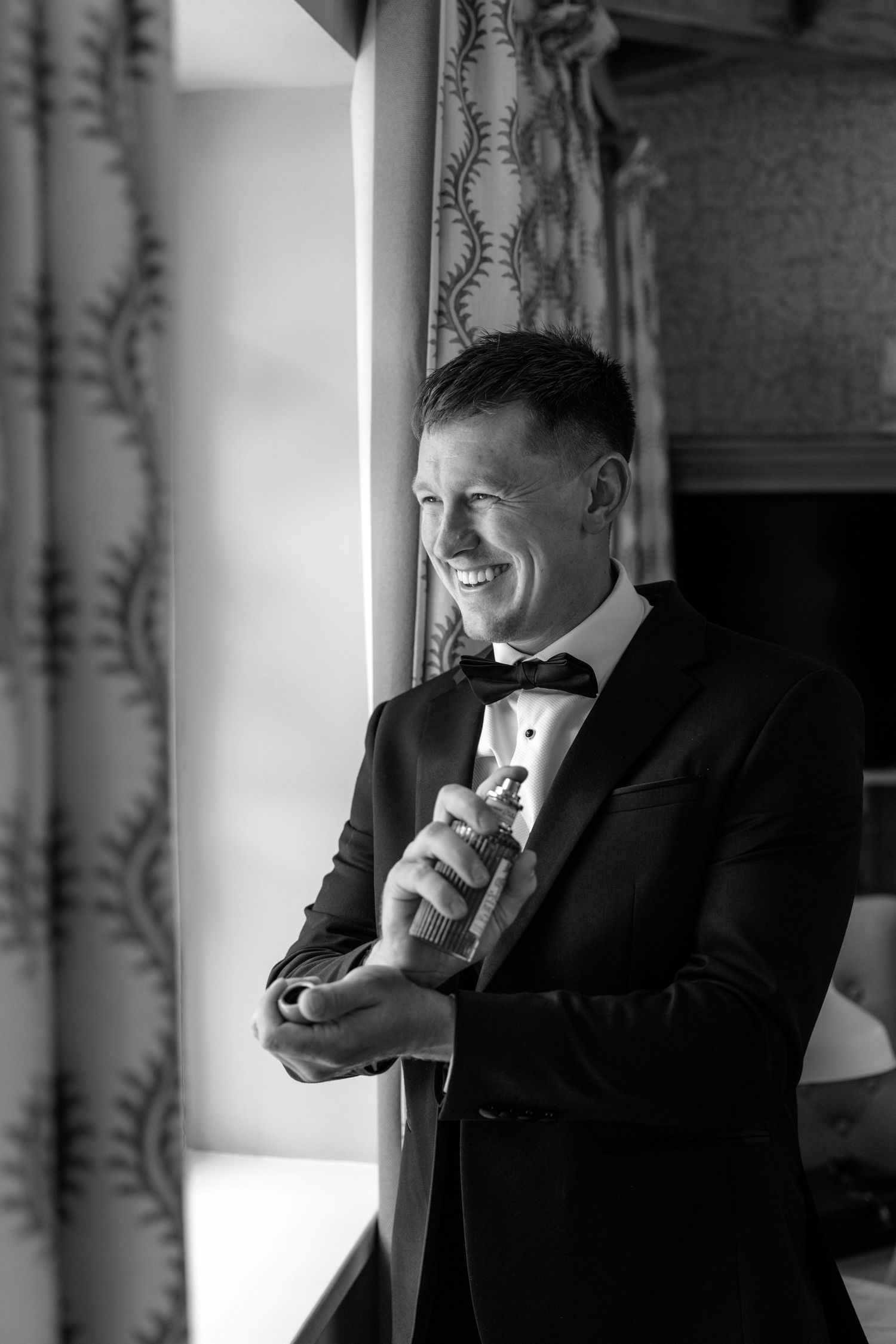 A series of four black and white photos showing a person in a tuxedo sitting near a window while sipping from a drink.