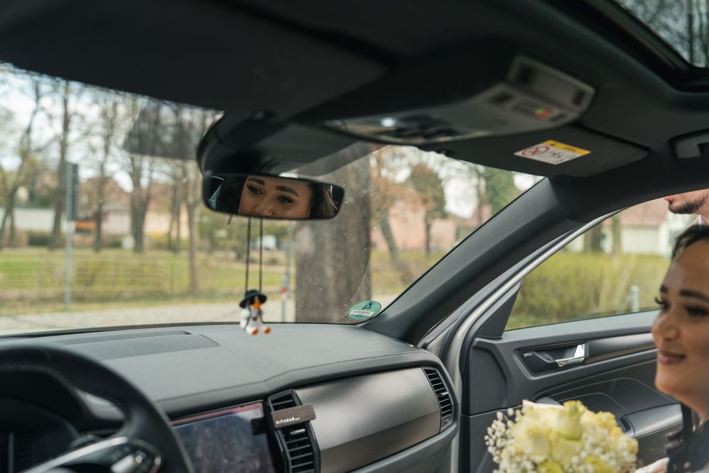 Braut mit Brautstrauß im Auto, Spiegelung im Fenster, Ankunft Schloss Vetschau