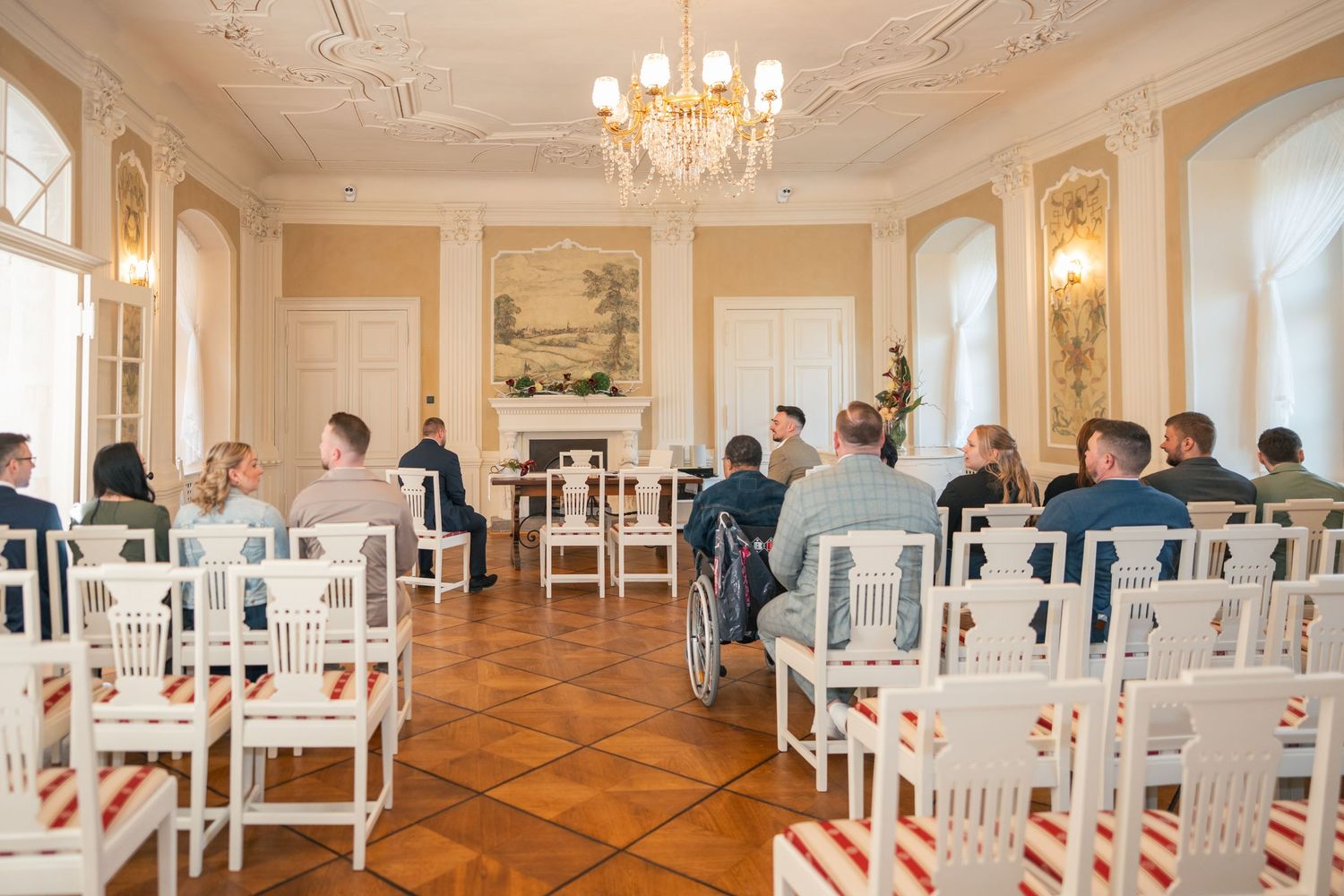 Saal Schloss Vetschau, Stühle mit roten Schleifen, Gäste bei Trauung