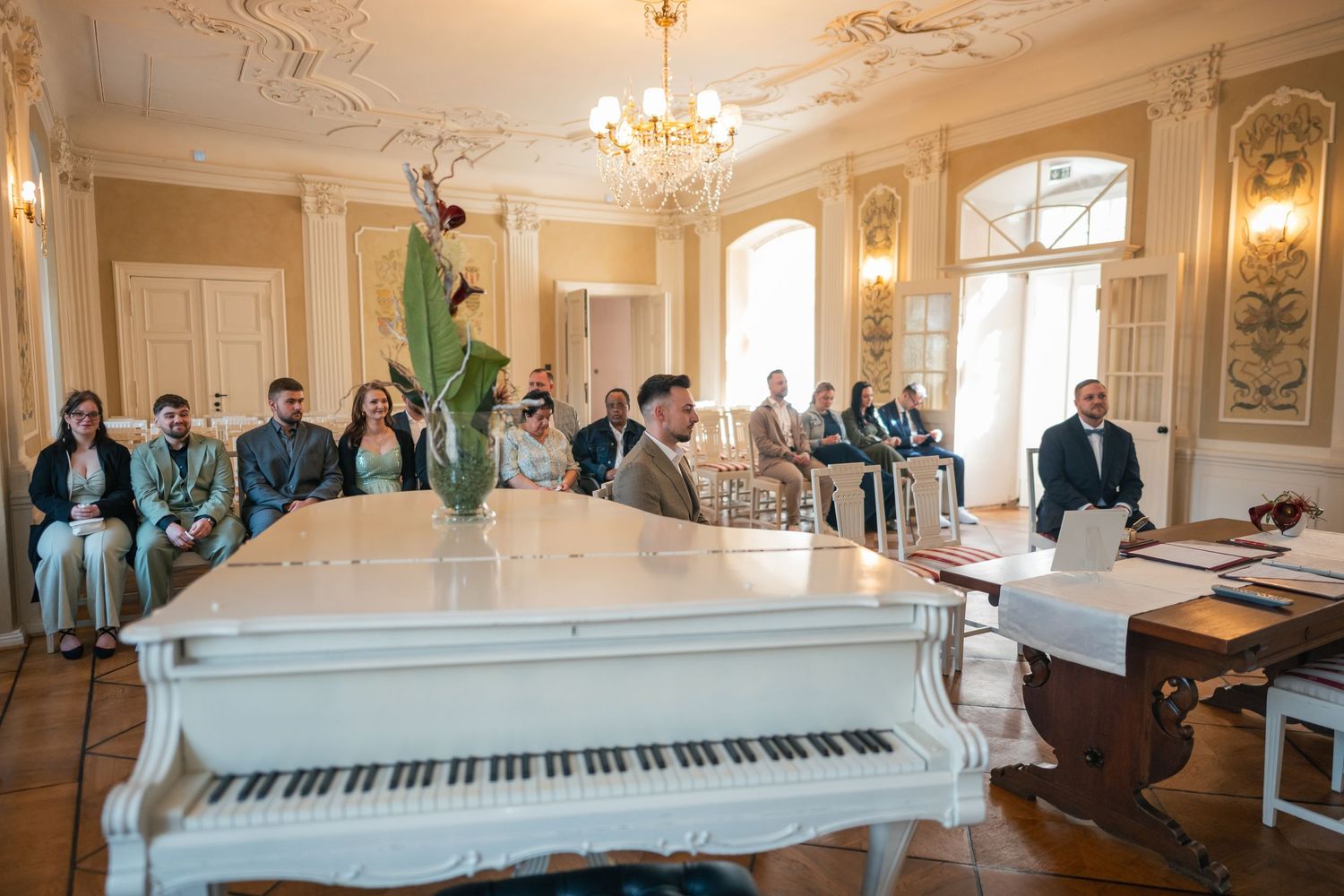 Saal Schloss Vetschau, Stühle mit roten Schleifen, Gäste bei Trauung