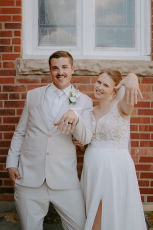 Happy couple sharing laughter in front of a classic brick building.
