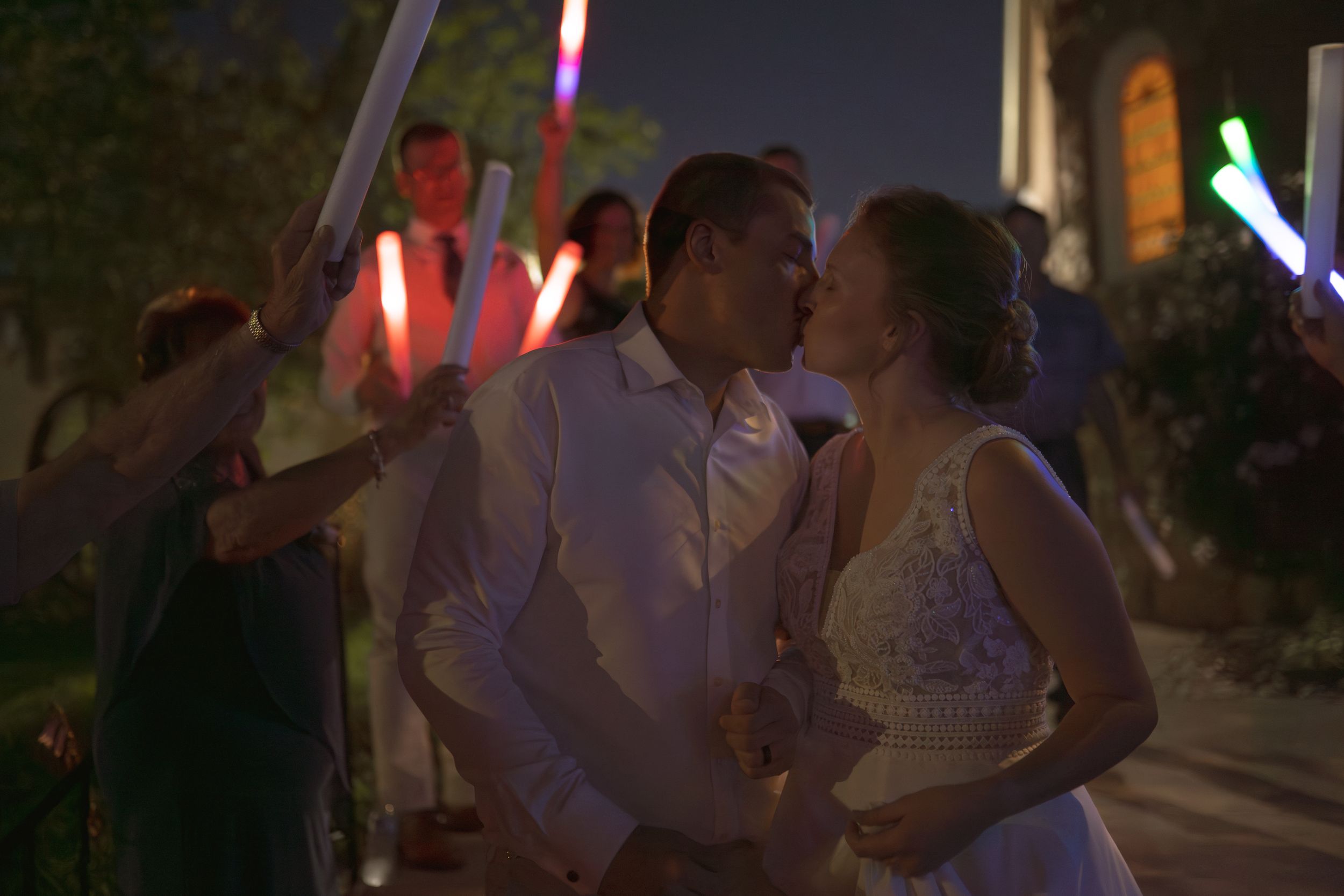 Wedding celebration at night with illuminated light sabers creating a festive atmosphere.