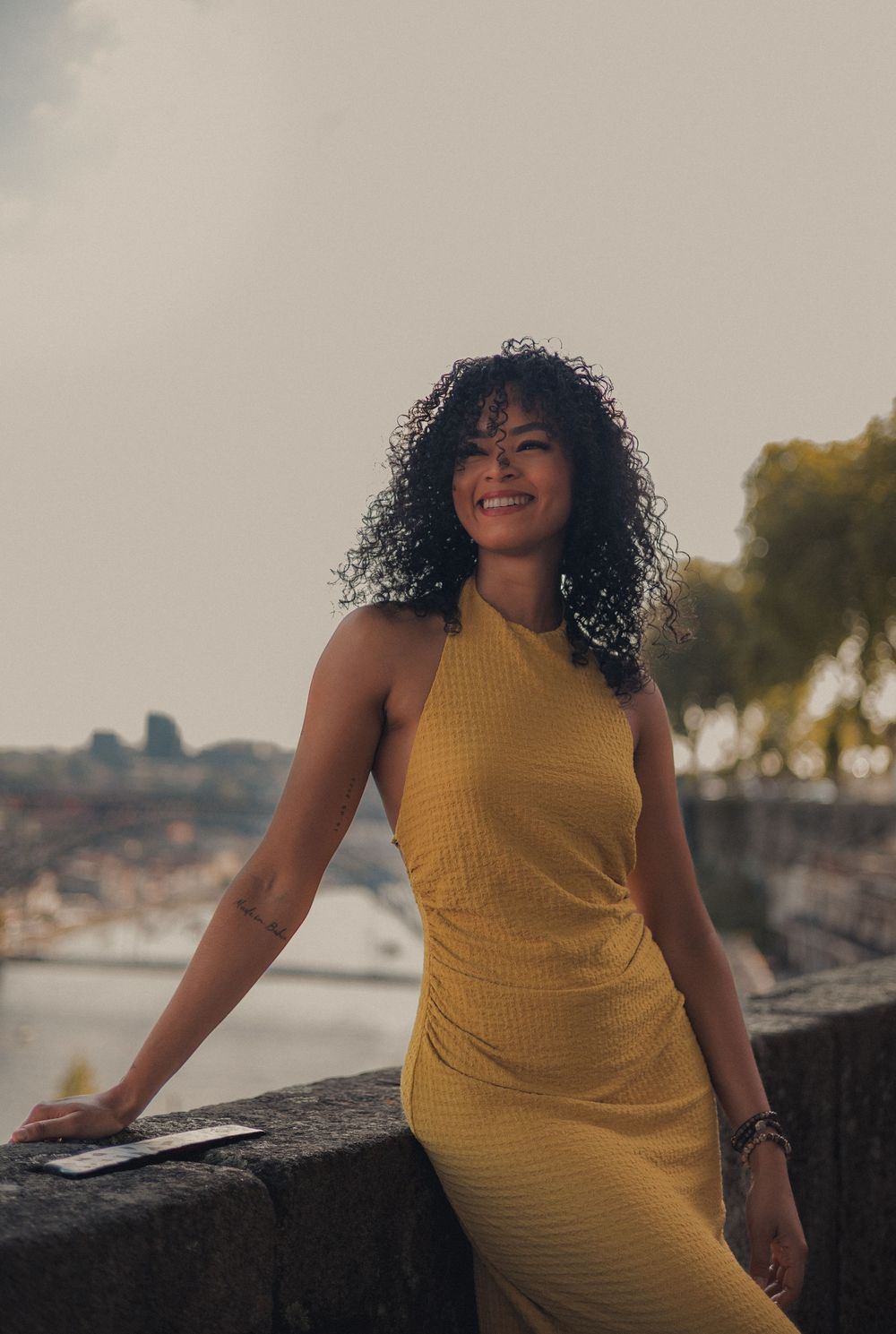 A scenic portrait overlooking Porto with a yellow dress catching golden hour light.