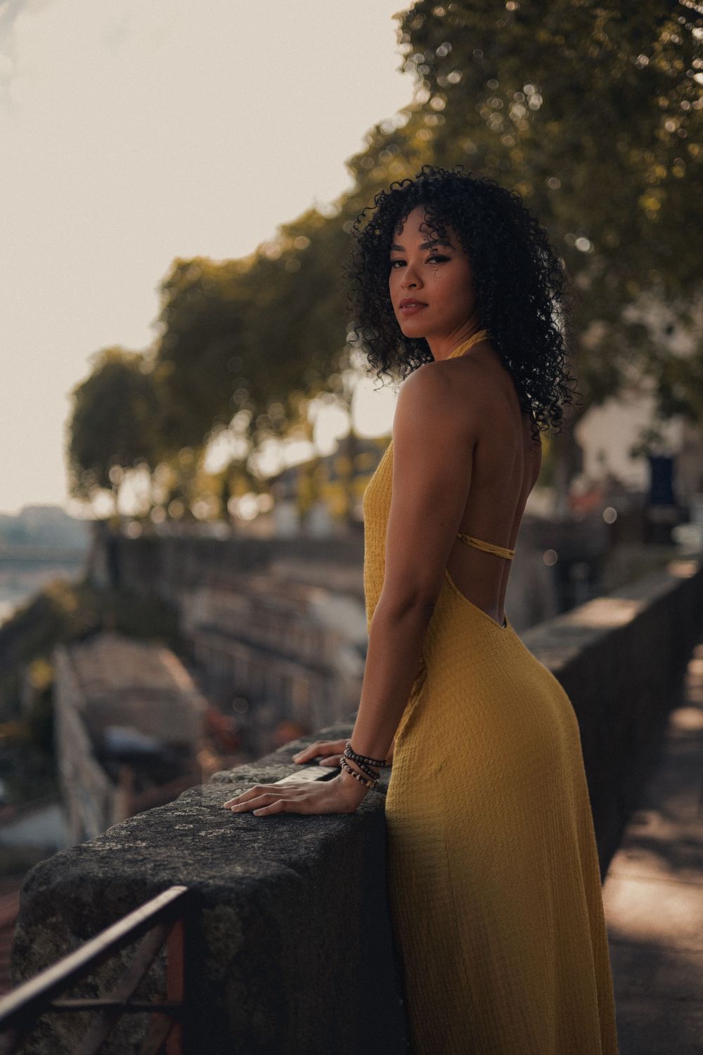 Fashion shoot on rustic terracotta rooftops overlooking a city in golden hour lighting.
