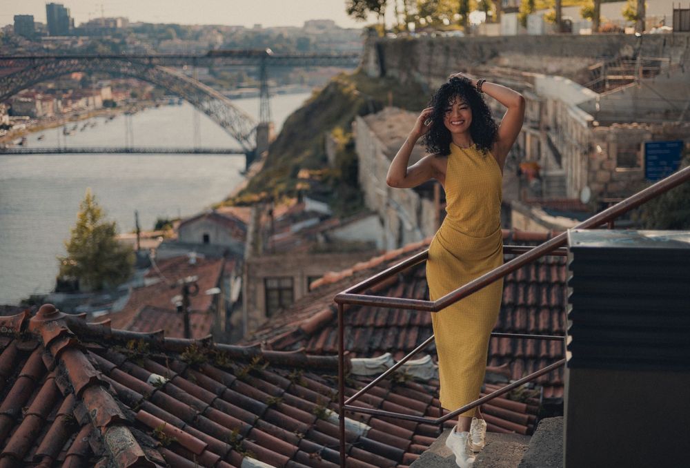 Rooftop photoshoot with dramatic cityscape and bridge views at sunset.