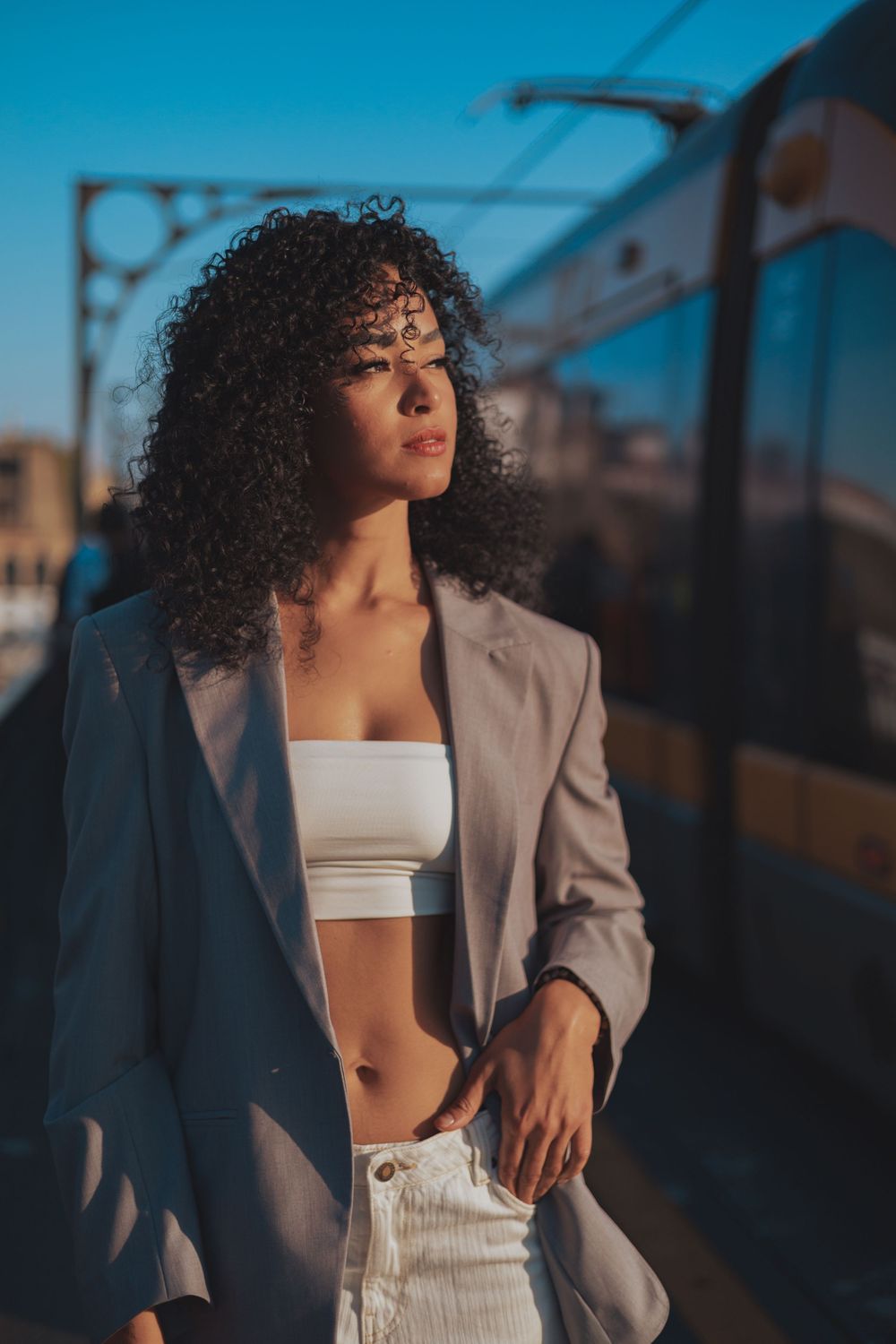 Fashion photography at dusk on bridge platform with dramatic lighting.