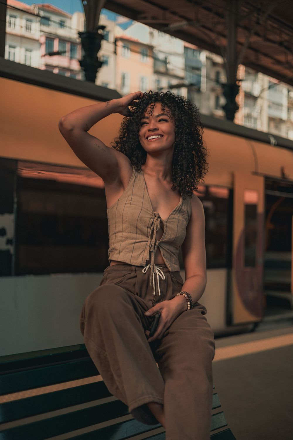 A joyful portrait at a train station platform with warm afternoon lighting.