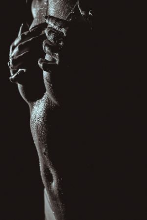 Dramatic black and white close-up of skin texture and shadows in artistic lighting.